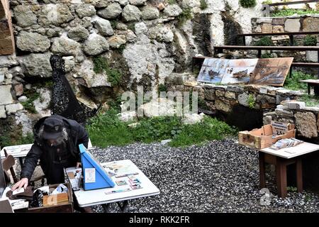 Izmir, Türkei. 28 Jan, 2019. Eine ältere Künstlerin mit Souvenirs und seine Gemälde prüft seine Habseligkeiten in den Ruinen von Genoese-Ottoman fünf Tore Schloss in der Altstadt. Credit: Altan Gochre | Verwendung weltweit/dpa/Alamy leben Nachrichten Stockfoto