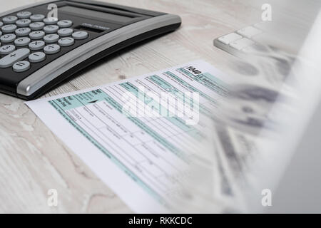 Uns Steuerformular 1040 neben Taschenrechner und Computer Tastatur. mit Geld in eine Reflexion. Steuern in Form Gesetz Dokument usa white Business Konzept Stockfoto