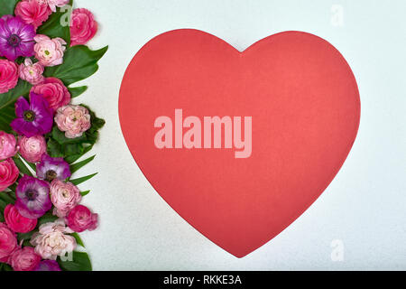 Schöne Karte für den Feiertag der Liebe. Hintergrund für den Valentinstag. Postkarte. Rosa Blumen auf weißem Hintergrund und roten Herzen für Text Stockfoto