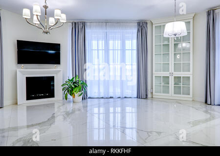 Minimalistische Inneneinrichtung Wohnzimmer in hellen Ton, mit Marmorböden, große Fenster und einen Kamin im TV Stockfoto