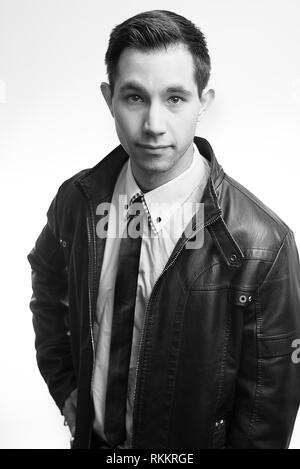 Junger Mann in Leder Jacke und Krawatte an Kamera suchen mit ernsten Blick, Maine, USA Stockfoto