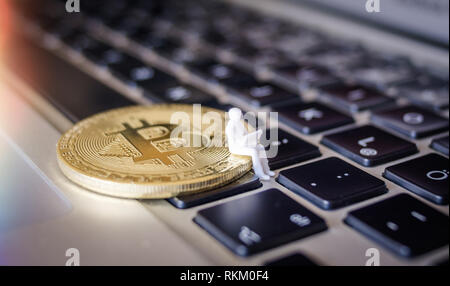 Miniatur Modell des Geschäfts Mann mit Laptop sitzen auf einem bitcoin Tastatur Stockfoto