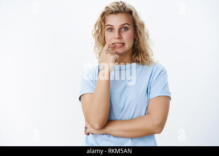 Mädchen in Gedanken versucht, denke, bis-Lösung, die den Finger auf die Lippen und Zähne wie die Wahl, zu entscheiden, wie Act posing konzentriert und das Nervensystem Stockfoto