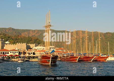 Wunderschöne Holz- Segelyachten in Marmaris Marina mit Bergen im Hintergrund angedockt Stockfoto