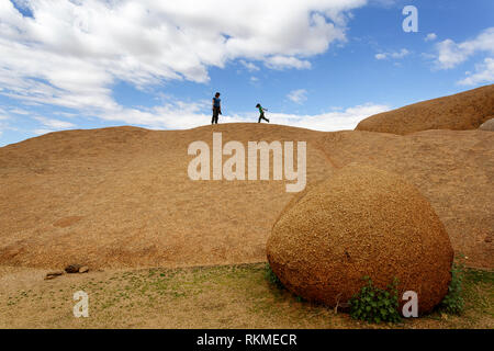 Mutter und Sohn gehen auf die Felsformationen in der Nähe der Granit Berg Spitzkoppe, Namibia, Afrika Stockfoto