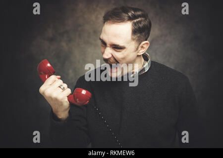 Zornigen mann Schreien am Telefon Stockfoto