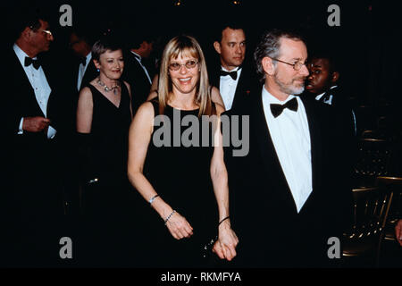 Regisseur Steven Spielberg, rechts, mit seiner Frau Kate Capshaw während des Abendessen zu Ehren der britische Premierminister Tony Blair im Weißen Haus Februar 5, 1998 in Washington, DC. Schauspieler Tom Hanks kann hinter gesehen werden. Stockfoto