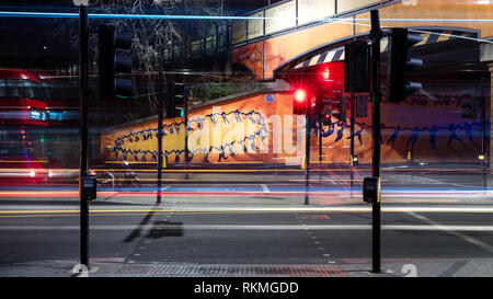 Nacht Trafic in London Lewisham Bereich mit roten Bus vorbei und die Linien drawen durch die Autos. Stockfoto