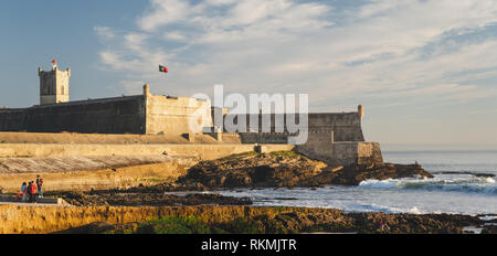 Estoril, Portugal - 12/31/18: Saint Julian Festung mit Lighthouse Tower, Strand (Praia) von Carcavelos, Wellen aus dem Atlantik, erodiert Strand Stockfoto