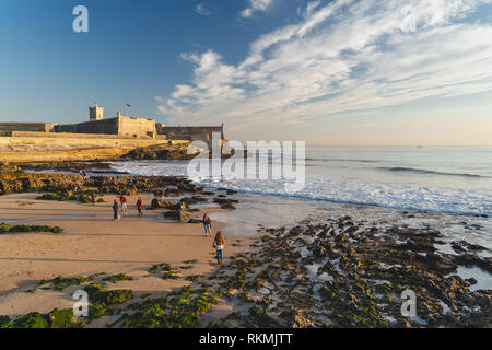 Estoril, Portugal - 12/31/18: Saint Julian Festung mit Lighthouse Tower, Strand (Praia) von Carcavelos, Wellen aus dem Atlantik, erodiert Strand Stockfoto