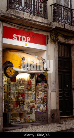 Lissabon, Portugal - 01/03/19: Auto in der Hälfte als Schild für Stop Shop in Downtown Chiado verwendet. Gelb die vordere Hälfte des classic car Schnitt für Fenster shop Stockfoto