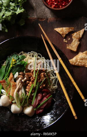 Chinesische Nudelsuppe mit Grill Schweinefleisch, Soja Huhn, Fisch und Gemüse Stockfoto