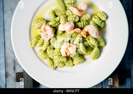 Hanmade Gnocchi mit Garnelen und Pesto-Sauce auf einem serviert Weiße Platte Stockfoto