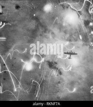 Ein Avro Lancaster von Nr. 1 Gruppe, Bomber Command, gegen Flammen, Rauch und Explosionen während des Angriffs auf Hamburg silhouetted, Deutschland Stockfoto