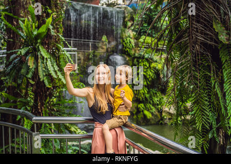 Mutter und Sohn nehmen ein selfie auf dem Hintergrund eines Wasserfalls Stockfoto