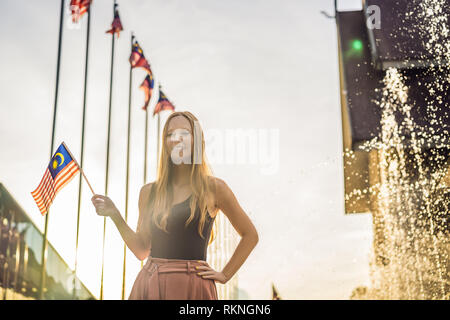 Junge Frau fährt in Malaysia. Hält die malaysischen Flagge Stockfoto