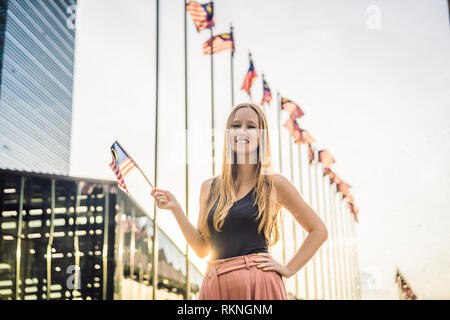 Junge Frau fährt in Malaysia. Hält die malaysischen Flagge Stockfoto
