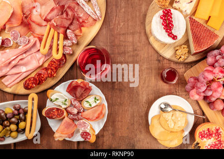 Charcuterie Verkostung. Ein Foto von vielen verschiedenen Schinken, Aufschnitt, und eine Käseplatte, geschossen von oben auf einem urigen Hintergrund Stockfoto