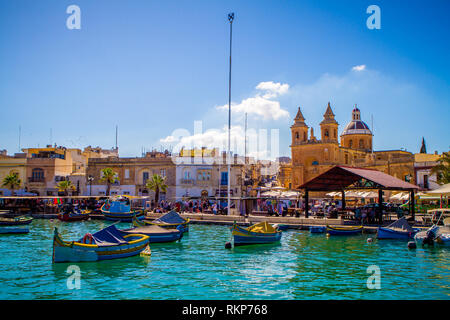 Pfarrkirche der Madonna von Pompei und Fischerboote in Marsaxlokk, Malta an einem sonnigen Tag Stockfoto