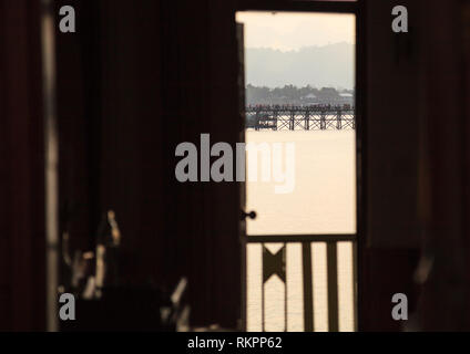 Natürliche Sonnenaufgang Landschaft Fenster Ansicht von Mon Brücke (Thai längste Holzbrücke) über Songkalia Fluss Hintergrund in Sangkhlaburi, Kanchanaburi Stockfoto