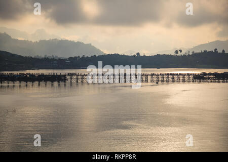 Natürliche Sonnenaufgang Landschaft Panoramablick von Mon Brücke (Thai längste Holzbrücke) über Songkalia Fluss Hintergrund in Sangkhlaburi, Kanchanab Stockfoto