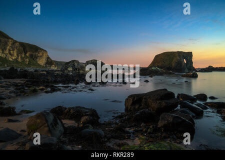 Das Meer in der Nähe von ballintoy Hafen auf Nordirland Antrim Coast stack. Lokal als Elephant Rock bekannt. In der Nacht mit Mond Licht aufgenommen. Stockfoto