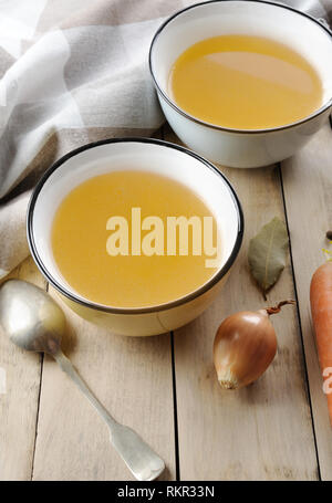 Brühe mit Zutaten. klare Brühe wird von simmering Fleisch oder Knochen und Gemüse. Mit Karotten, Zwiebeln, Petersilie, Sellerie zubereitet und serviert. Stockfoto