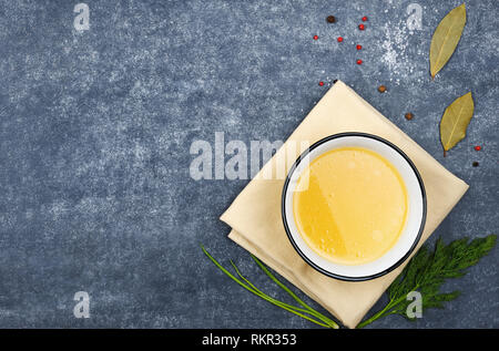 Kreative Gestaltung aus der Brühe auf grauem Hintergrund. Reich an Eiweiß, speziell Gelatine und Mineralien wie Kalzium und Phosphor. Essen Konzept. Stockfoto