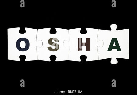 Vier Stücke von Puzzle mit Buchstaben OSHA sind zusammen auf schwarzen Hintergrund verbunden Stockfoto