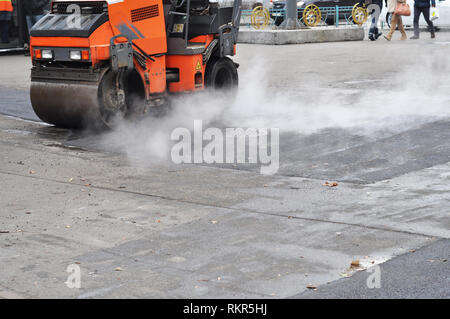 Road Repair, Verdichter legt Asphalt. Baustellen auf Festlegung eines neuen Asphalt. Reparatur Bürgersteig und Festlegung neuer Asphalt Patchmethode im Freien. Stockfoto