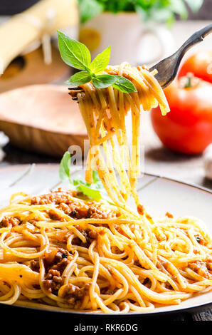 Nahaufnahme des italienischen Spaghetti Bolognese mit Basilikum dienen an der Platte. Traditionelle hausgemachte italienische Küche Rezept. Kochen und Gastronomie Konzept. Stockfoto