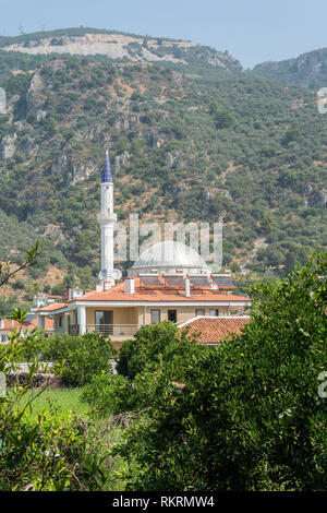 Akyaka, Mugla, Türkei - 30. Juli 2016. Moschee in Akyaka Dorf in der Provinz Mugla in der Türkei, mit der Vegetation und die umliegenden Gebäude. Stockfoto
