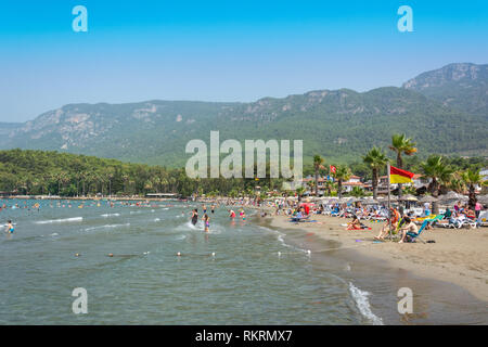 Akyaka, Mugla, Türkei - 30. Juli 2016. Akyaka Strand im Zentrum von Akyaka Dorf in der Provinz Mugla in der Türkei, mit Sakar Berge im backgroun Stockfoto