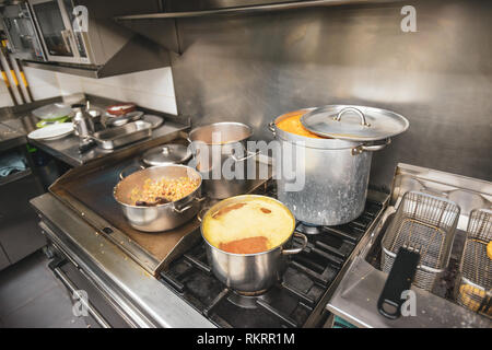 Essen kochen in Töpfen und Pfannen auf dem Herd in einem Restaurant Küche in Valencia, Spanien. Stockfoto