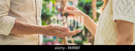 Immobilienmakler geben Schlüssel zum Eigentümer der Wohnung, Kauf Verkauf von Immobilien. Nahaufnahme der männlichen Hand die Hausschlüssel von Realtor. Hypothek für Stockfoto
