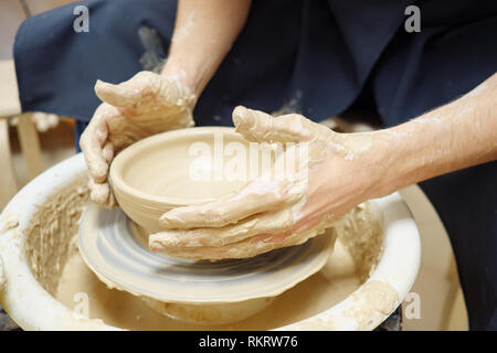 Frau Mann ihre Hände dub Wand Kanne, formt aus Ton auf Kreis. Die schmutzigen Hände im Ton. Stockfoto