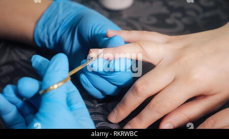 Closeup Schoß einer Frau Hände im Nagelstudio, Maniküre, durch eine Kosmetikerin. Stockfoto
