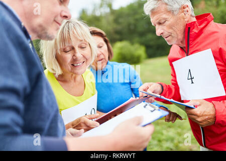 Senior Group mit Zwischenablage an einem Spiel oder Wettbewerb Geocaching Stockfoto