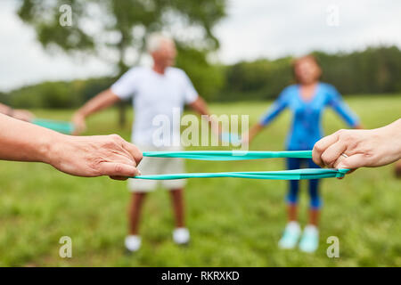 Senior Group tun Physiotherapie Übung mit Stretch Band im Kreis Stockfoto