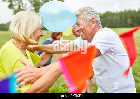 Senioren auf einer Party spielen Ballons, um sich gegenseitig kennen zu lernen Stockfoto