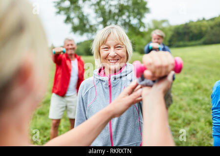 Ältere Frau zu tun Hantel Training mit Trainer oder Physiotherapeuten im rehab Stockfoto