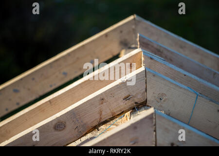 Close-up Detail der Dachrahmen aus grobem Holz Bauholz Balken auf dem Hintergrund von Misty Mountain Landschaft im ökologischen Bereich. Gebäude, Dach, constructi Stockfoto