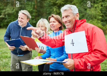 Aktive Gruppe des seniors an der Schnitzeljagd als ein Spiel in der Natur Stockfoto