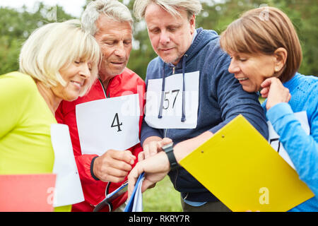 Senioren bei einer Schatzsuche oder Schnitzeljagd in der Teambuilding workshop Stockfoto