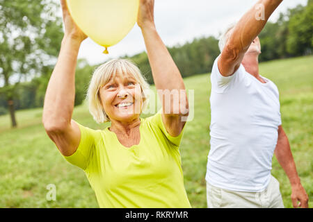 Senior Paar spielen mit Luftballons in den Garten zu einem Sommerfest Stockfoto