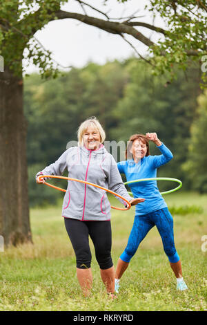 Zwei Frauen, Senior Sport im Park, ihre Fitness mit der Reifen Stockfoto