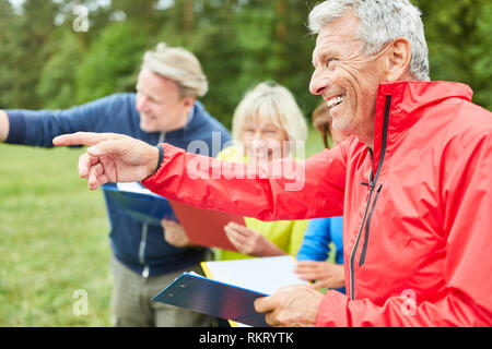 Gruppe von Senioren genießen eine Schnitzeljagd oder Geocaching in der Natur Stockfoto