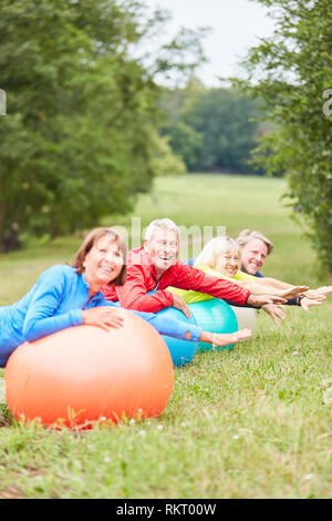 Gruppe von Senioren Spaß macht eine Übung Ball Übungen in der Reha Klasse Stockfoto