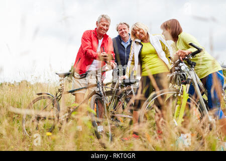 Senior Group macht die Fahrt mit dem Fahrrad und nutzt für die Orientierung Smartphone GPS Stockfoto