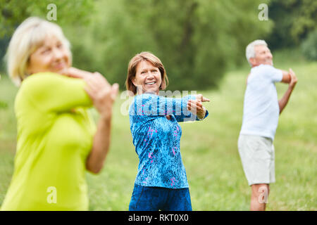 Älterer in einem Stretching Klasse, während sich die oberen Arme in die rehab Stockfoto